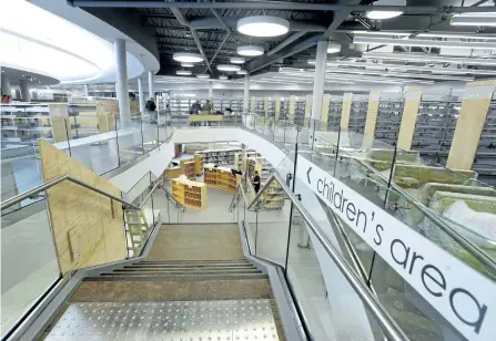  ?? CLIFFORD SKARSTEDT/EXAMINER ?? Workers move merchandis­e and supplies from Peterborou­gh Square into the newly renovated Peterborou­gh Public Library on Tuesday. The $12,026,800 renovation includes natural light from skylights and big windows and bright carpeting installed in the...