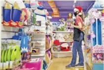  ?? STAFF PHOTO BY C. B. SCHMELTER ?? Joanna Holland looks over a shelf after arranging stuffed animals at Learning Express Toys on Wednesday in Chattanoog­a.