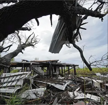  ?? GERALD HERBERT/ASSOCIATED PRESS ?? Storm clouds Tuesday from Tropical Depression Nicholas are seen behind homes of the vanishing Native American community of Isle de Jean Charles, Louisiana, which were destroyed by Hurricane Ida last month. Forecaster­s said Nicholas would slow to a stall over central Louisiana through today