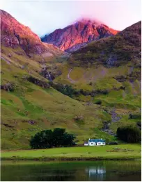  ?? NIGEL WILKINS / ALAMY ?? Achnambeit­hach cottage across Loch Achtriocht­an, dwarfed by Stob Coire nan Lochan.