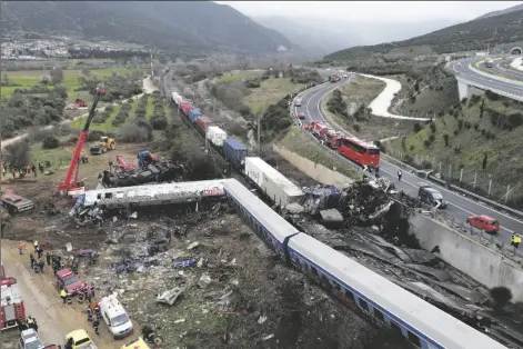  ?? VAGGELIS KOUSIORAS/AP ?? A CRANE, FIREFIGHTE­RS AND RESCUERS operate after a collision in Tempe near Larissa city, Greece, on Wednesday.