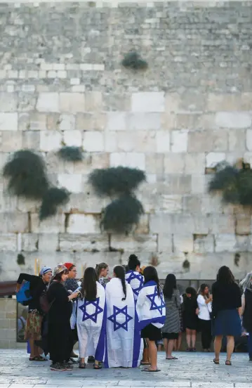  ??  ?? JEWISH VISITORS stand next to the Western Wall.