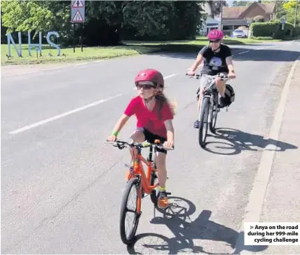  ??  ?? Anya on the road during her 999-mile
cycling challenge