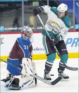  ?? PHOTOS: DAVID ZALUBOWSKI — THE ASSOCIATED PRESS ?? The Ducks’ Max Comtois, right, shoots the puck at Avalanche goaltender Philipp Grubauer during the second period of Tuesday night’s game in Denver.