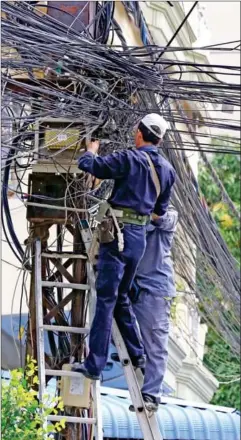  ?? HENG CHIVOAN ?? Technician­s work to establish a new power connection in central Phnom Penh late last week.