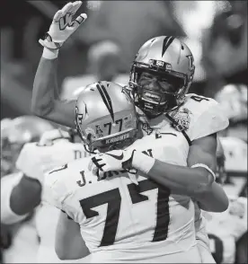  ?? JOHN BAZEMORE/AP PHOTO ?? Central Florida wide receiver Tre’Quan Smith (4) embraces offensive lineman Jake Brown (77) after beating Auburn in the Peach Bowl on Monday at Atlanta.