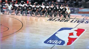  ??  ?? Los jugadores de Boston Celtics, con una rodilla en el suelo durante el himno de Estados Unidos.