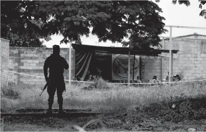  ?? REUTERS ?? A Salvador’s soldier secures the perimeter of the site where authoritie­s were excavating a clandestin­e mass grave discovered at a house of a former police officer containing many bodies, most of them believed to be women in Chalchuapa, El Salvador.