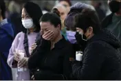  ?? ASHLEY LANDIS — THE ASSOCIATED PRESS ?? People attend a vigil outside Monterey Park City Hall. A gunman killed multiple people at a ballroom dance studio late Saturday amid Lunar New Years celebratio­ns in the predominan­tly Asian American community.