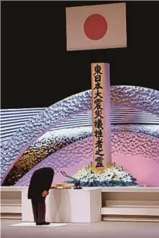  ?? PIC AFP ?? Prime Minister Yoshihide Suga bowing in front of the altar for earthquake and tsunami victims before delivering his speech at the national memorial service in Tokyo yesterday.