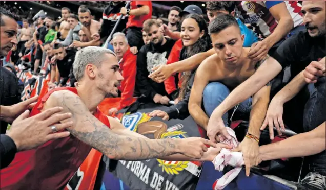  ?? ?? Antoine Griezmann entrega su camiseta a un aficionado tras la conclusión del partido contra el Bayer Leverkusen disputado el miércoles.