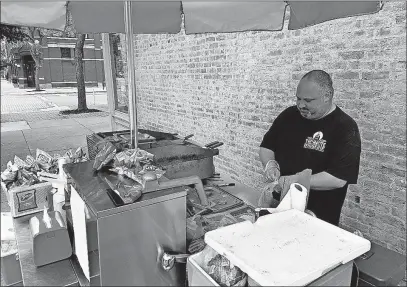  ??  ?? Trump supporter Greg Fahnestock mans his hot dog cart in the heart of downtown Chillicoth­e.