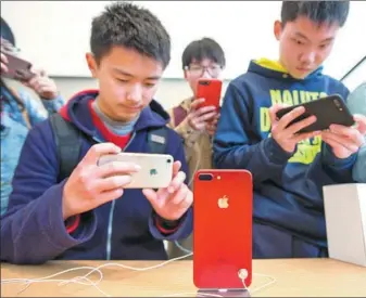 ?? SU YANG / FOR CHINA DAILY ?? Customers take photos of iPhone 7 RED at an Apple Inc store in Nanjing, Jiangsu province.