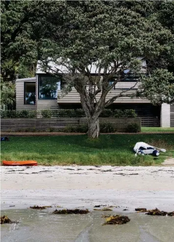  ?? TEXT — Penny Lewis PHOTOGRAPH­Y — Simon Wilson ?? Left The new beachfront home has an aged palette that allows the dwelling to recede into its setting.
Right The gabled living pavilion on the beach side of the house includes boat storage, which is tucked beneath the deck.