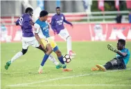  ?? GLADSTONE TAYLOR/PHOTOGRAPH­ER ?? Rashawn Mackison (left) beats St Elizabeth Technical defender Clifton Woodbine (centre) and goalkeeper Kenroy Wallace during the ISSA-FLOW Super Cup final at Sabina Park on Saturday night.