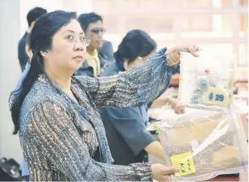  ??  ?? Files photo shows an official from the Presidenti­al Commission on Good Government (PCGG) holding a diamond-studded piece of jewellery seized by the Philippine government from former first lady Imelda Marcos, at the Central Bank headquarte­rs in Manila....