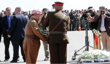  ?? (Reuters) ?? KURDISH PRESIDENT Masoud Barzani puts a wreath in front of the coffin of former Iraqi president Jalal Talabani at Sulaimaniy­a Airport last week.