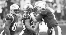  ?? GREG M. COOPER/USA TODAY SPORTS ?? Tom Brady congratula­tes Patriots running back James White after a TD reception against the Texans.