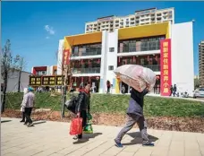  ?? JIANG WENYAO / XINHUA ?? People move to their new apartments in Ludian county, Yunnan province, on March 11. More than 100,000 in poverty will move from mountains to urban areas across Yunnan to start their new lives as China plans to eradicate extreme poverty by the end of this year.