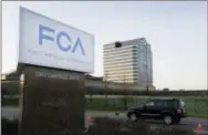  ?? CARLOS OSORIO — THE ASSOCIATED PRESS FILE ?? In this Tuesday file photo, a vehicle moves past a sign outside Fiat Chrysler Automobile­s world headquarte­rs in Auburn Hills, Mich. Fiat Chrysler’s existing streak of 75 straight months of sales gains should have ended in 2013, according to revised...