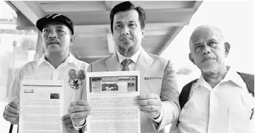  ?? — Bernama photo ?? Zulkarnain (centre) shows the documents purportedl­y related to the RM1.5 billion siphoning case in Sabah at the MACC headquarte­rs.