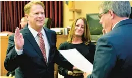  ?? GREENE/THE HERALD-MAIL VIA AP ?? Washington County Circuit Court Clerk Kevin Tucker, right, swears in Andrew F. Wilkinson as a circuit court judge on Jan. 10, 2020, as Wilkinson’s wife, Stephanie, watches.
Julie E.