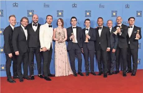  ?? ASSOCIATED PRESS ?? The cast and crew of “La La Land” pose in the press room with the award for best motion picture, musical or comedy, at the 74th annual Golden Globe Awards Sunday at the Beverly Hilton Hotel. “La La Land” won seven awards.