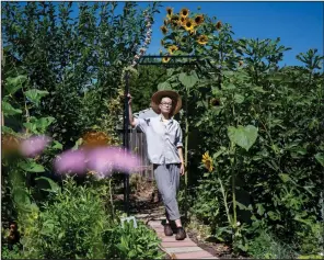  ?? (For The Washington Post/Marlena Sloss) ?? Charis Hill stands in the backyard he has transforme­d into an oasis of plants, trees and herbs despite chronic health conditions.
