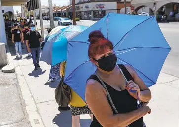  ?? Photograph­s by Irfan Khan Los Angeles Times ?? AMELIA GURRERO stands in line for more than an hour for Bank of America ATMs this month in Calexico. The Calexico West Port of Entry — one of two in Imperial County — is the third-busiest land port in the state.