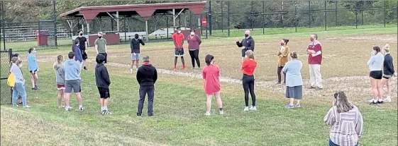  ?? NICK MALLARD PHOTOS / SENTINEL & ENTERPRISE ?? The Fitchburg High cross country teams take part in a COVID-19 informatio­nal session prior to the first practice of the season on Friday. Below, Fitchburg High field hockey coach Jennifer Scott, left, looks on as her team runs drills at Game On Fitchburg on Friday afternoon. At bottom, Fitchburg field hockey players run through a drill during Friday's practice.