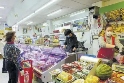  ?? ELISA MANZANO ?? Vecinos realizan su compra en un supermerca­do de cercanía, en una imagen de archivo.