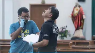  ??  ?? SLEMAN: Indonesian police examine the scene after a knife attack at a church during a Sunday mass in Sleman, Yogyakarta province yesterday. —AFP