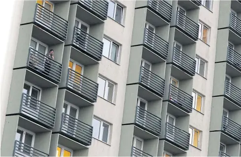  ??  ?? A student makes a phone call on a balcony of a dormitory in Prague.