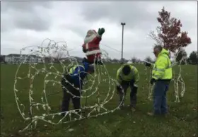  ?? RICHARD PAYERCHIN — THE MORNING JOURNAL ?? From left, Lorain Public Property Department equipment operators Jason Stoyka and Steve Ferguson install Christmas decoration­s with working crew leader Don Queen at Black River Landing on Nov. 20. Much of the lights and activities of Lorain’s Waterfront Winterfest will be at Black River Landing this year.