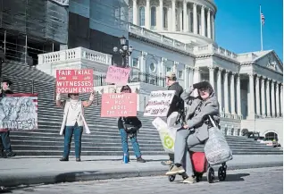  ?? T.J. KIRKPATRIC­K THE NEW YORK TIMES ?? A small group of protesters outside the House side of the Capitol in Washington on Wednesday. The House intended to send articles of impeachmen­t to the Senate on Wednesday.