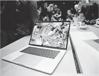  ?? TONY AVELAR, EUROPEAN PRESSPHOTO AGENCY ?? Fans converge on the new MacBooks in a demo room Thursday at Apple HQ in Cupertino, Calif.