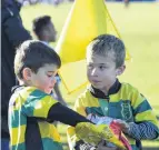  ?? PHOTOS: GERARD O’BRIEN ?? Fuel stop . . . Green Island Gold’s Ethan Dettling (6) helps himself to some of Finn Pulley’s (7) popcorn as the under 7s rest between matches.