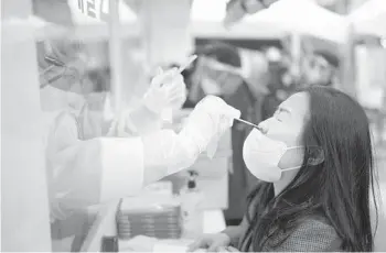  ?? CHANG W. LEE/THE NEW YORK TIMES ?? A woman undergoes a nasal swab test for COVID-19 on Tuesday in Seoul, South Korea. While some people have no complaints about their tests, it can be squirm-inducing and quite uncomforta­ble for others.