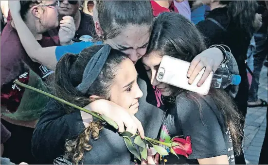  ?? JOEL AUERBACH / AP ?? Estudiante­s del instituto Marjory Stoneman Douglas de Parkland (Florida) lloran la muerte de 17 personas, entre compañeros y profesores