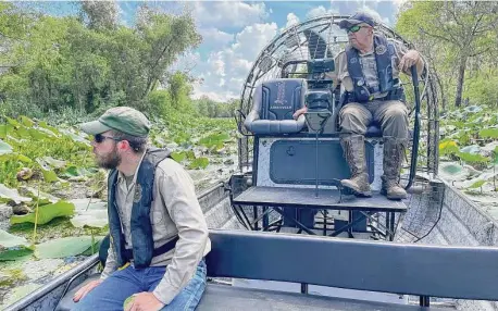  ?? Photos by Scott Solomon / Contributo­r ?? Cord Eversole, left, and his father, Barry Eversole, a game warden with Texas Parks and Wildlife, search for alligators at Brazos Bend State Park in Fort Bend County.