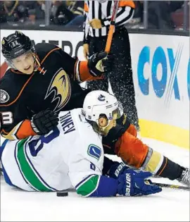  ?? Mark J. Terrill Associated Press ?? DUCKS RIGHT WING Jakob Silfverber­g and Canucks defenseman Christophe­r Tanev battle for the puck during the second period.