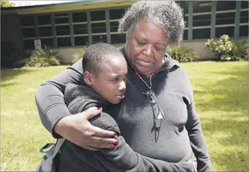  ?? Al Seib Los Angeles Times ?? ANNIE HALL hugs her son Deartonne Graves, a sixth-grader at Webster Middle School. Parents at the Westside school, which already shares space with one charter, fear that adding another could stunt its growth.