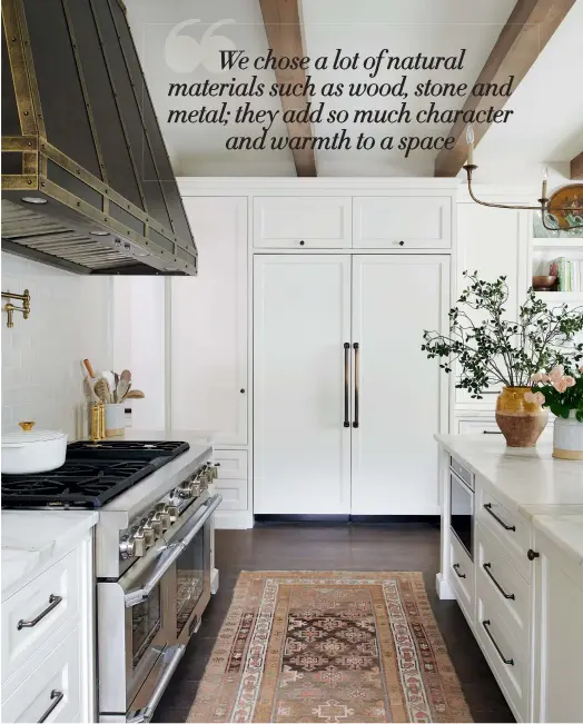  ??  ?? Hali let the custom-built vent hood and runner shine by toning down the rest of the kitchen with a creamy white scheme. Built-in display shelves ( far right) showcase a collection of cookbooks and French ceramics. Range by Thermador, Tasco Appliances; runner, Elte. OPPOSITE: The kitchen design balances old and new, combining wooden beams and antiqued brass hardware with vintage Calacatta marble counters and light cabinets. Vent hood, cabinets, Top Notch Cabinets; stools, Lee Industries; faucets by Waterstone, Cesario & Co.; hardware by Rocky Mountain Hardware, Oakville Fine Hardware.