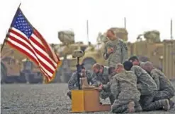  ??  ?? In this photograph taken on September 14, 2010, US army officers with the 101st Airborne Division pay their respects by the boots, gun, helmet and dog-tags of US army First Lieutenant Todd W Weaver displayed during a memorial ceremony in his honor at...