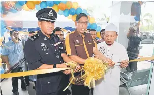  ?? — Gambar Bernama ?? RASMI: Baharom Embi (tengah) memotong reben sebagai menandakan perasmian premis Ar Rahnu Tekun Nasional Cawangan Johor Bahru di Jalan Padi 1, Bandar Baru Uda, semalam.