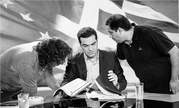  ?? Yorgos Karahalis / Bloomberg news ?? Greek Prime Minister Alexis Tsipras, centre, goes on TV in Athens on Monday. The market is unsure what he will do as Greece faces default.