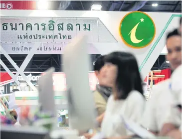  ?? PATIPAT JANTHONG ?? IBank staff provide services at a money expo. The Finance Ministry is expected to inject B2 billion in the bank.