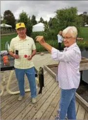  ?? CHAD FELTON — THE NEWS-HERALD ?? Carolyn Bowen, of Mentor, shows off her largemouth bass catch at Senior Day at Lake Metroparks Farmpark in Kirtland on Sept. 14. At left is Carolyn’s husband, Jim.