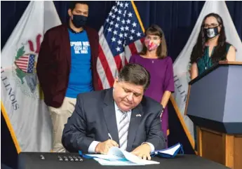  ?? ANTHONY VAZQUEZ/SUN-TIMES ?? Gov. J.B. Pritzker signs bills to expand access to mental health care in Illinois at the Thompson Center on Wednesday.