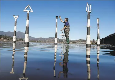  ?? Photos by Scott Strazzante / The Chronicle ?? Ceramic artist Jeff Downing puts the finishing touches on “Aqua Metric Markers” in Richardson Bay.